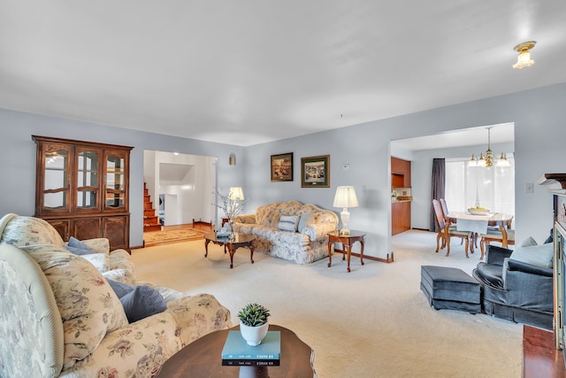 living room with light colored carpet and an inviting chandelier