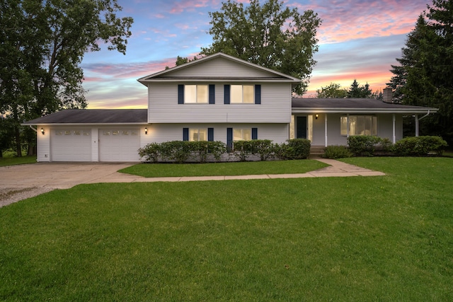 view of front of property with a yard and a garage