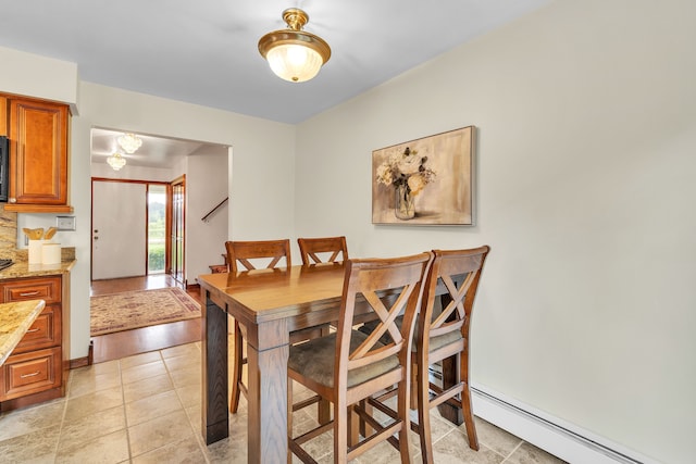 dining area with baseboard heating and light hardwood / wood-style flooring