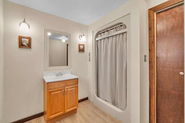 bathroom with vanity, curtained shower, and wood-type flooring