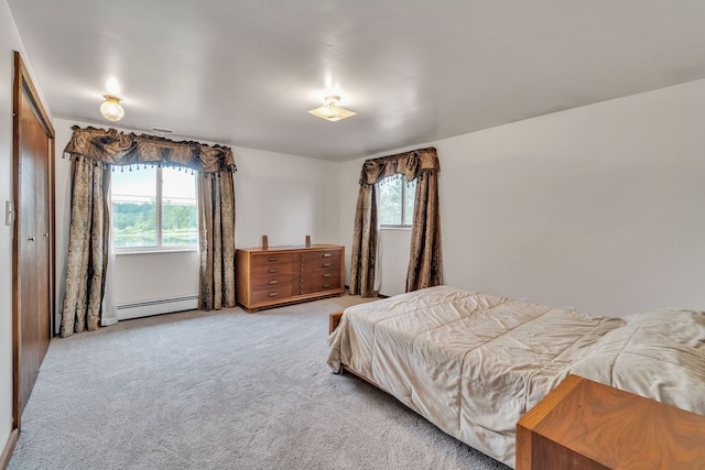 carpeted bedroom with baseboard heating and a closet