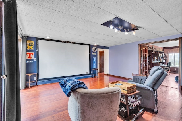 home theater featuring hardwood / wood-style flooring and a drop ceiling