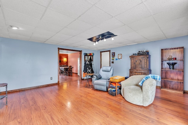 living room featuring hardwood / wood-style flooring and a drop ceiling