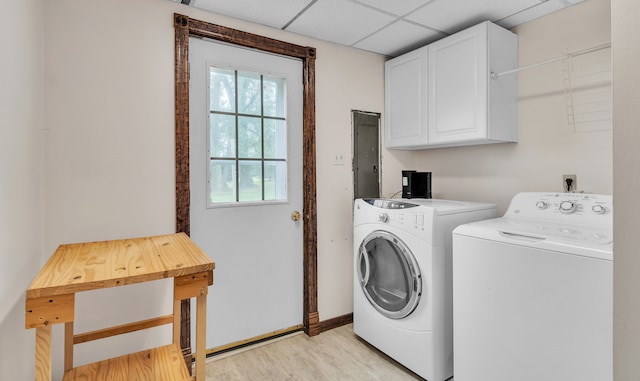 laundry room featuring cabinets, independent washer and dryer, electric panel, and light hardwood / wood-style floors