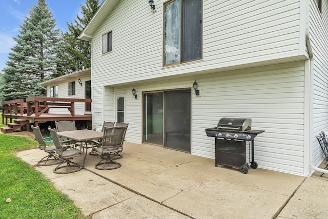 view of patio with area for grilling and a wooden deck