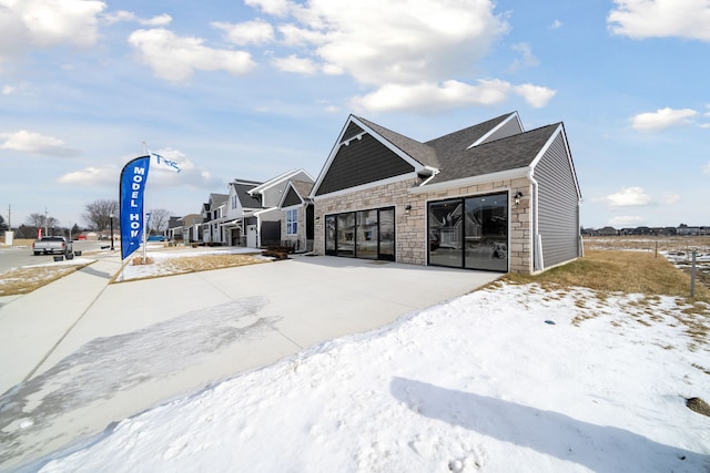 exterior space featuring driveway, stone siding, and an attached garage