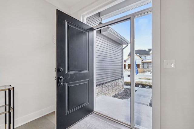 doorway featuring baseboards and wood finished floors