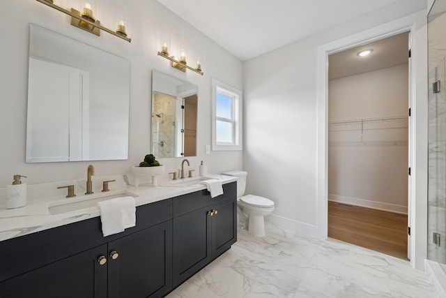 bathroom featuring a stall shower, marble finish floor, a sink, and a spacious closet