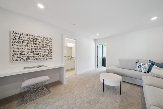 living area with light carpet, baseboards, built in desk, and recessed lighting