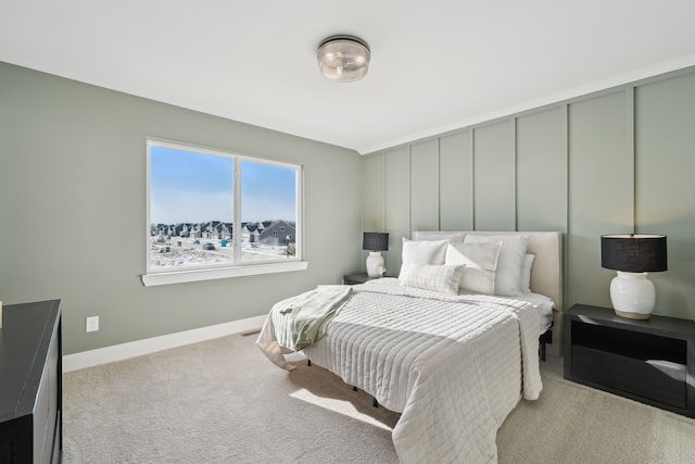 bedroom featuring light carpet and baseboards