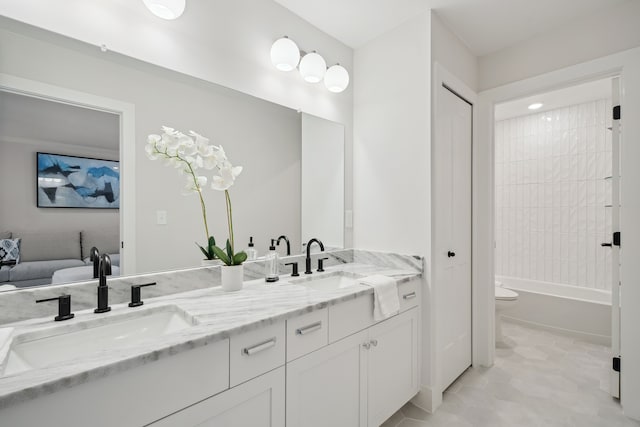 full bath featuring double vanity, shower / bathing tub combination, a sink, and toilet