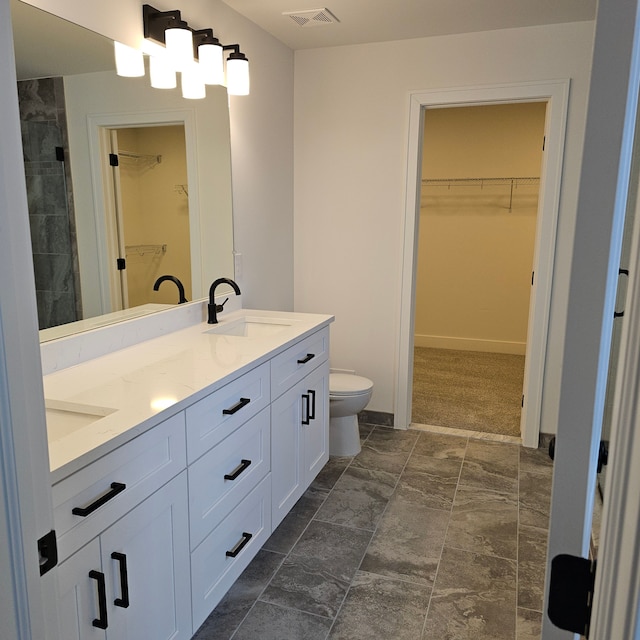 bathroom featuring vanity, toilet, and walk in shower