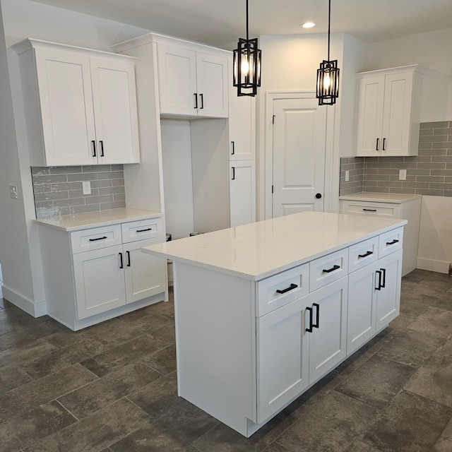 kitchen featuring hanging light fixtures, a kitchen island, white cabinets, and backsplash