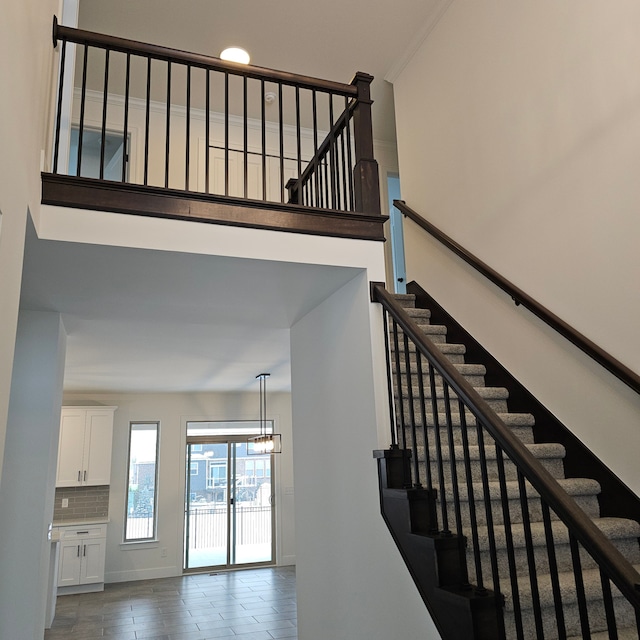 stairs featuring an inviting chandelier and a towering ceiling