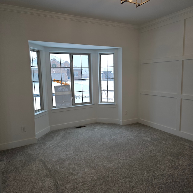 carpeted empty room featuring crown molding and a chandelier