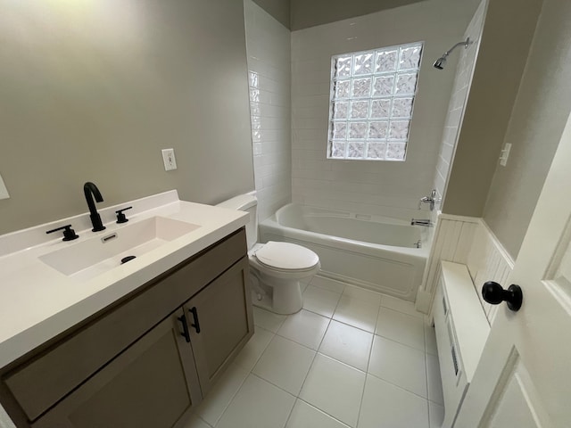 full bathroom with tile patterned floors, vanity, tiled shower / bath combo, and toilet