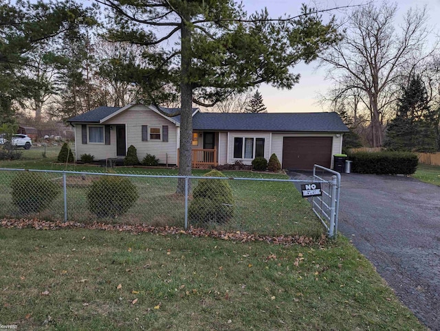 single story home featuring a garage and a lawn