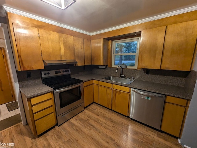 kitchen with light hardwood / wood-style floors, crown molding, sink, and appliances with stainless steel finishes