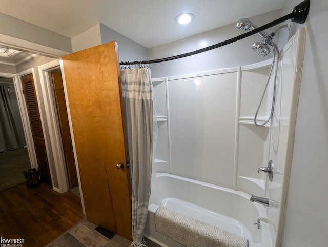 bathroom with wood-type flooring and shower / tub combo