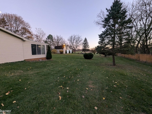 yard at dusk featuring an outdoor structure