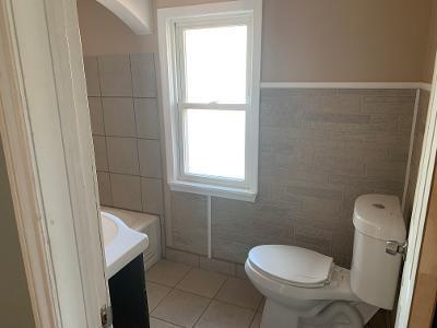 bathroom with tile patterned floors, vanity, toilet, and tile walls