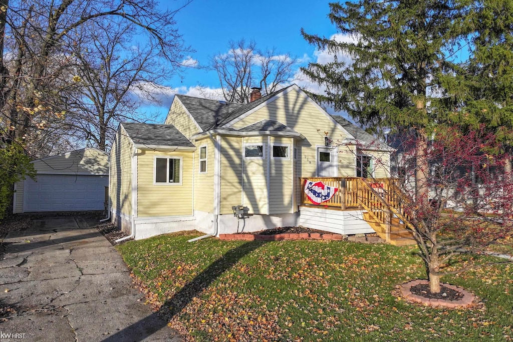 bungalow-style house with a front yard, an outdoor structure, and a garage