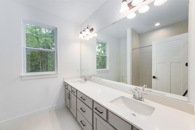 bathroom with a wealth of natural light, vanity, and toilet