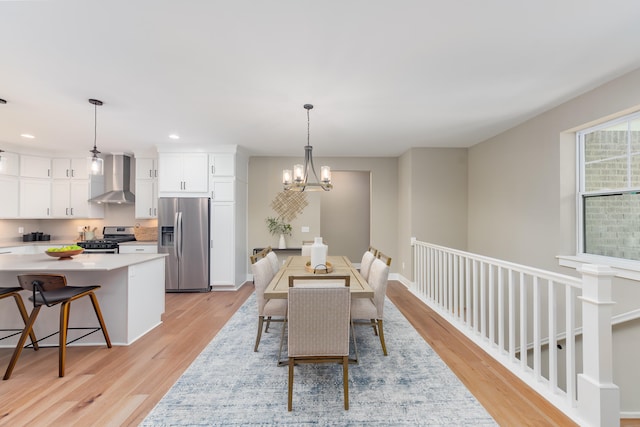 dining room with light hardwood / wood-style flooring and a chandelier