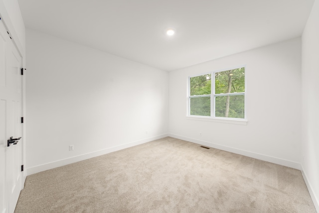 unfurnished room with light carpet