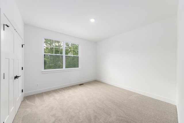 unfurnished room featuring light carpet