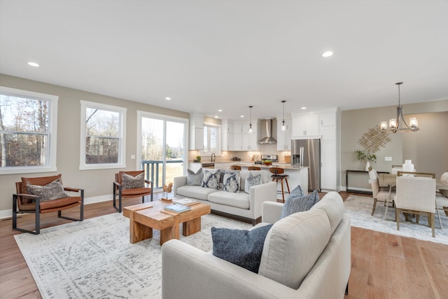 living room featuring a chandelier and light wood-type flooring