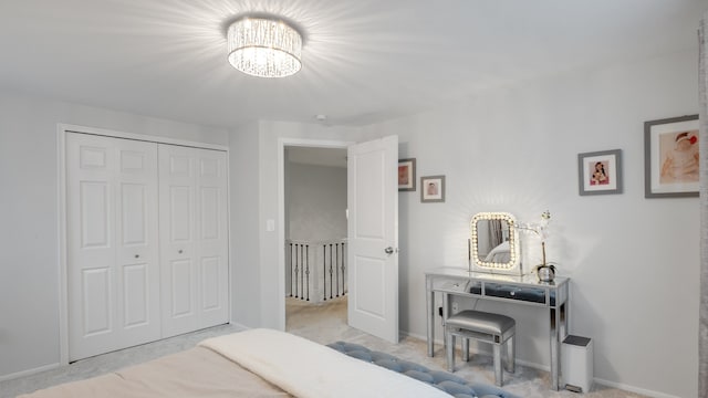 bedroom with a notable chandelier, light carpet, and a closet