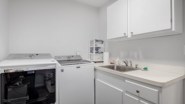 laundry area with washer and dryer, cabinets, and sink