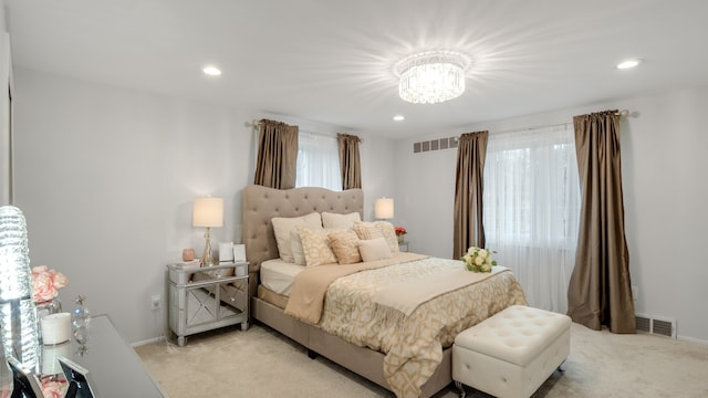 bedroom with a notable chandelier, light colored carpet, and multiple windows