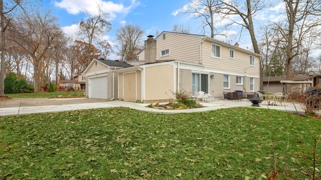 back of house with a lawn, a patio area, and a garage