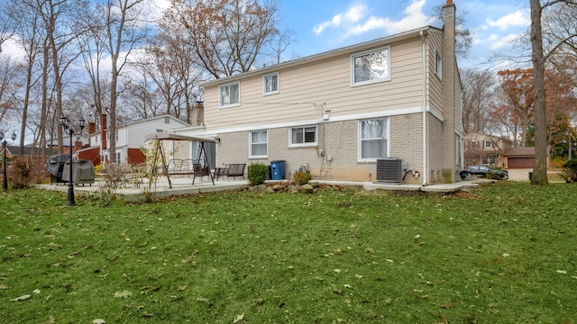 back of house with cooling unit, a patio area, and a yard