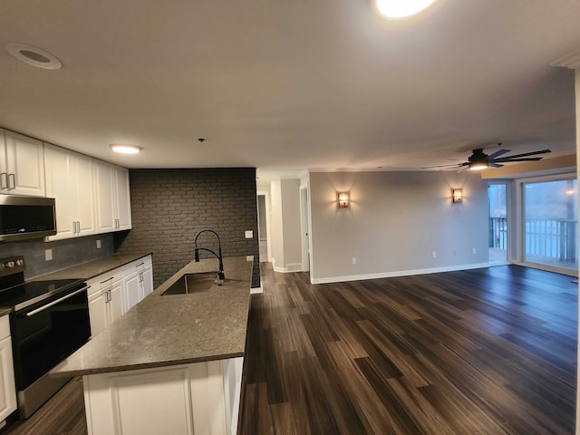 kitchen with white cabinetry, sink, a center island, dark wood-type flooring, and stainless steel appliances