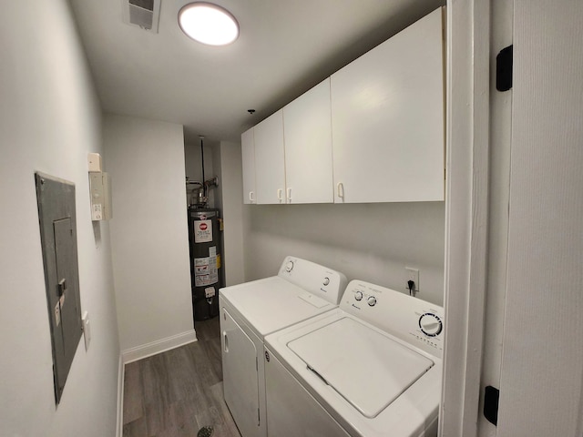 laundry room featuring cabinets, dark hardwood / wood-style flooring, gas water heater, washer and clothes dryer, and electric panel