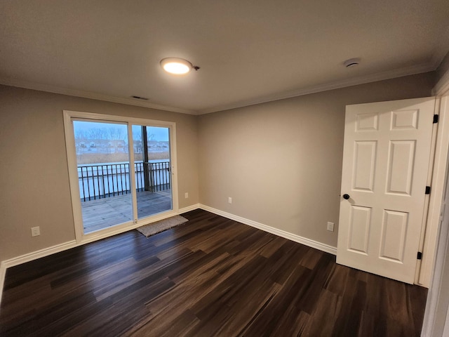 empty room with crown molding and dark wood-type flooring