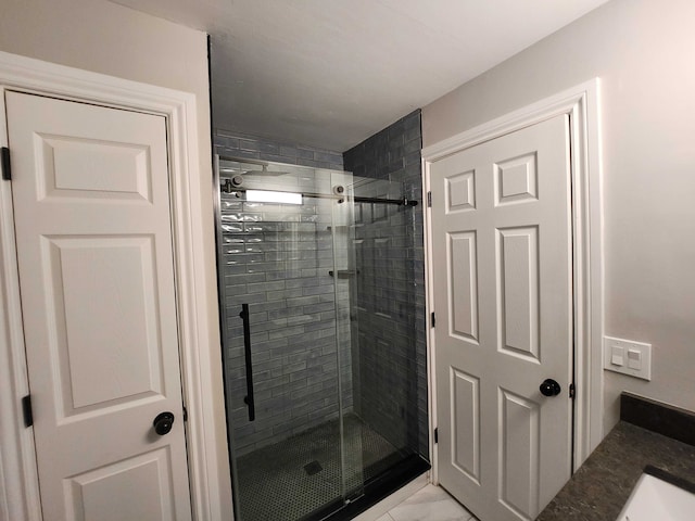 bathroom with vanity and a shower with door