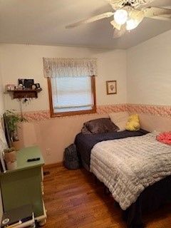 bedroom with ceiling fan and dark hardwood / wood-style flooring