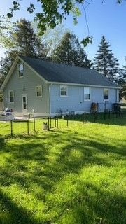 rear view of property featuring a lawn