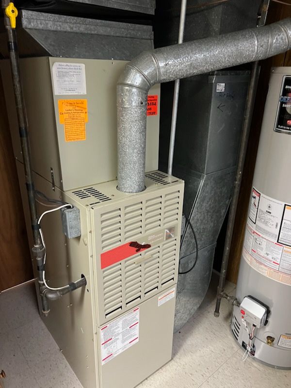 utility room featuring heating unit and water heater