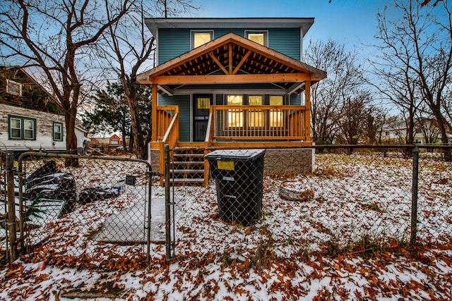 snow covered rear of property with a porch