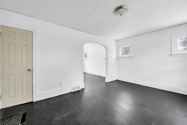 empty room with plenty of natural light and dark hardwood / wood-style flooring