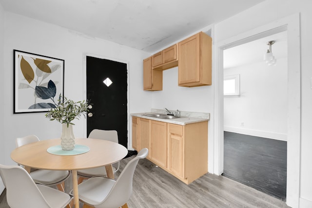 kitchen with light brown cabinetry, light hardwood / wood-style flooring, and sink