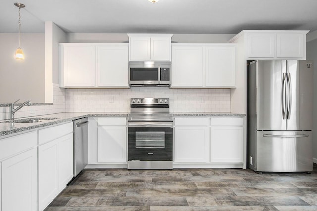 kitchen featuring light stone counters, white cabinetry, and stainless steel appliances