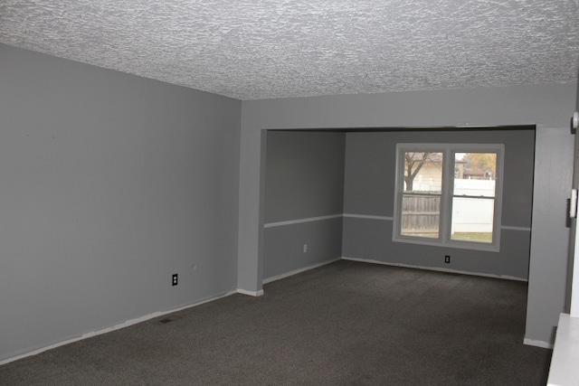 carpeted spare room featuring a textured ceiling