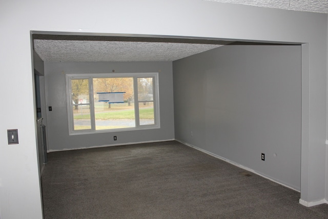 carpeted empty room with a textured ceiling