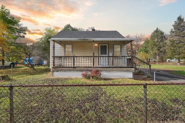 view of front of home with a porch and a yard